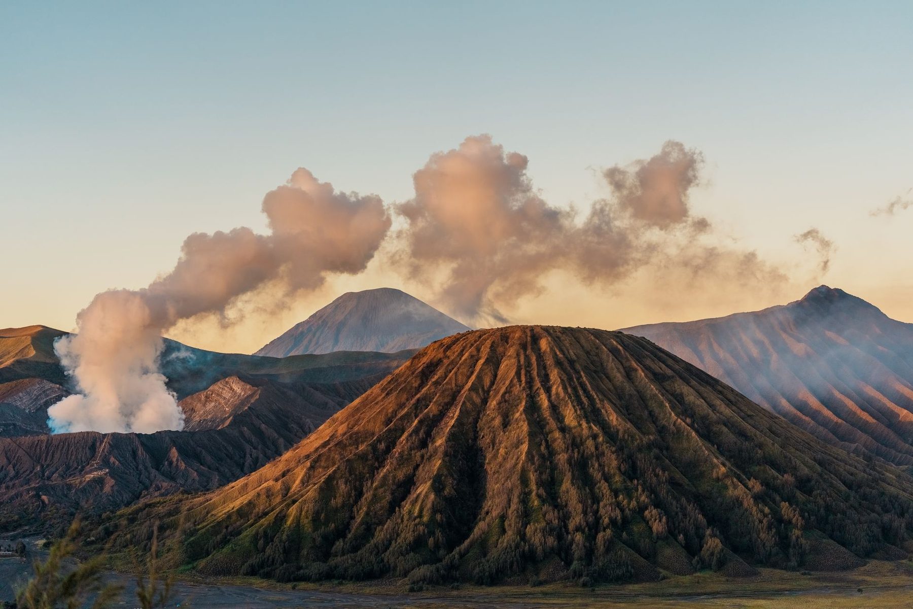 Matahari terbit di atas Gunung Bromo, Jawa Timur, dengan lanskap vulkanik dan awan uap