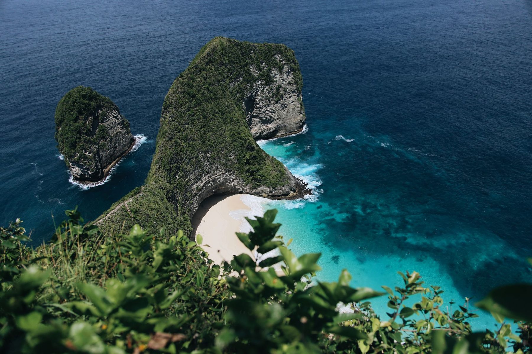 Pandangan udara pantai Nusa Penida, Bali, dengan air biru kehijauan dan tebing hijau