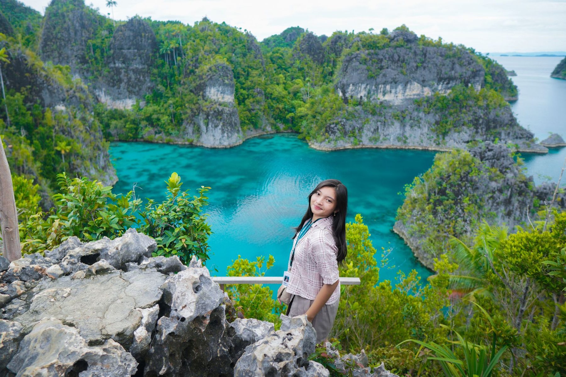Perempuan menikmati pemandangan gugusan pulau Raja Ampat, Papua Barat, Indonesia